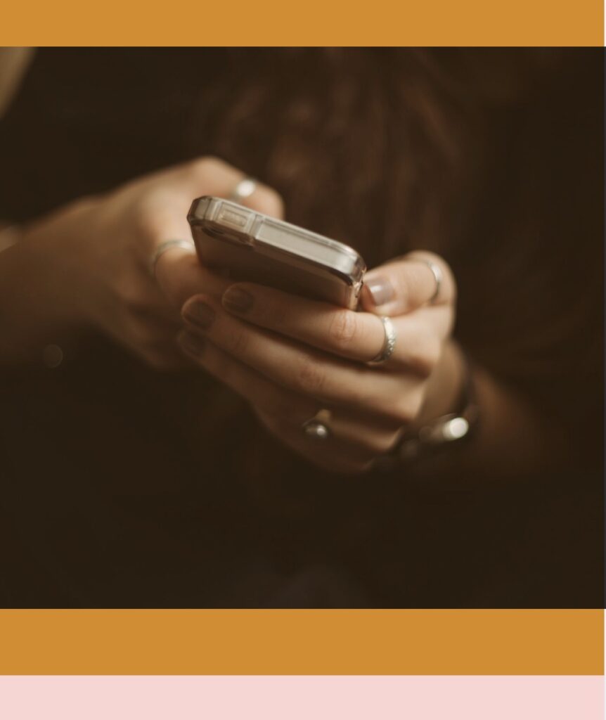 Photo of hands with silver rings and nail polish holding smartphone by Priscilla Du Preez on Unsplash